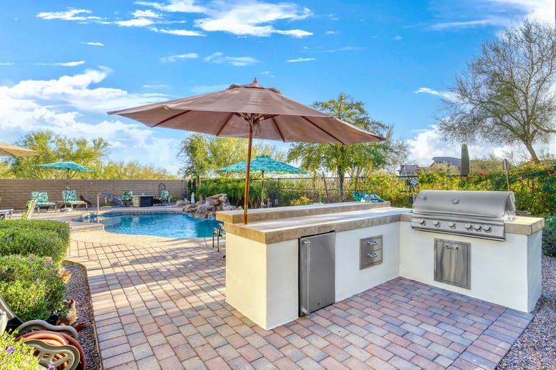 Outdoor kitchen with pool and pavers